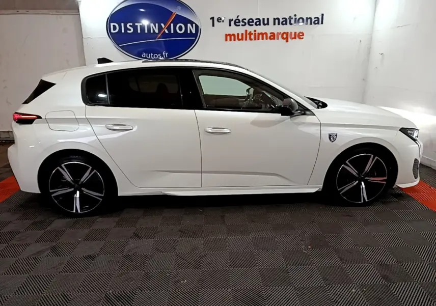 Peugeot 308 PHEV 180 E-EAT8 GT blanc vue de profil côté gauche, jantes noires à inserts argentés.