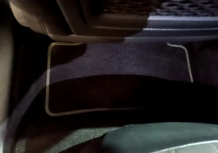 Tapis de sol noir avec surpiqûres claires côté conducteur d'une Peugeot 308 PHEV 180 E-EAT8 GT blanche de 2022.