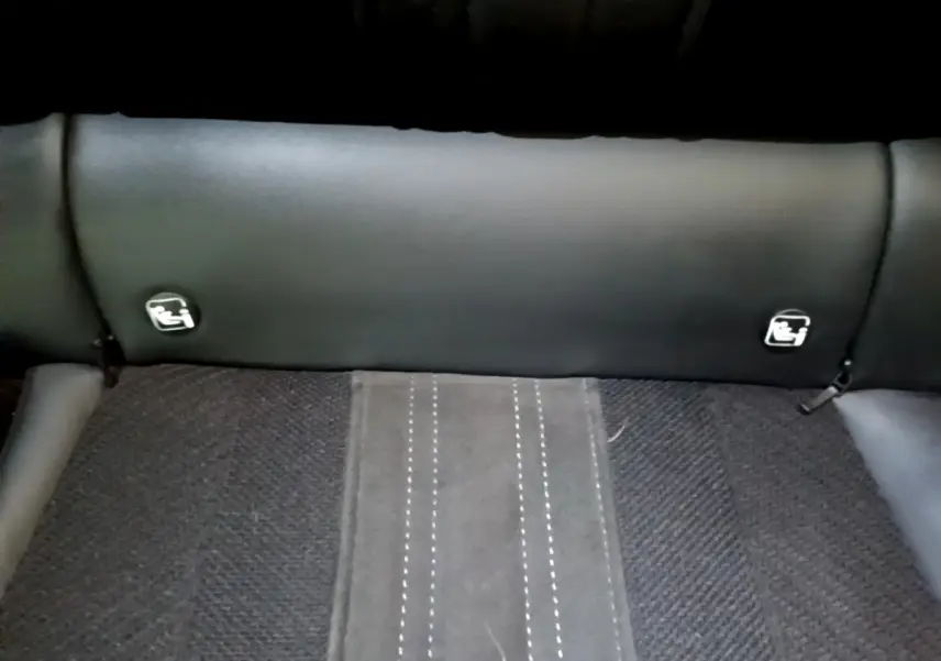 Gros plan sur la banquette arrière noire de la Peugeot 308 PHEV 180 GT avec logos Isofix visibles sur le dossier.