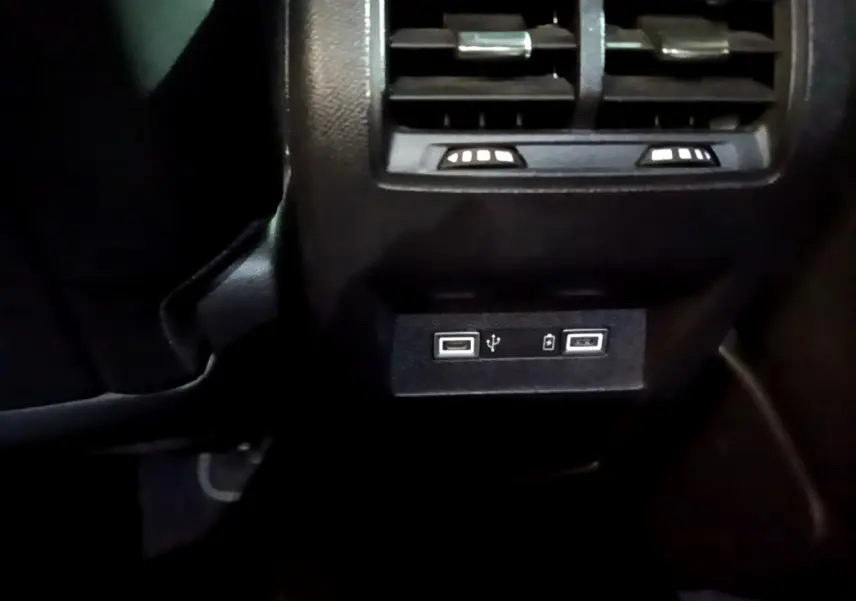 Prise USB double et bouches d’aération arrière noires dans l’habitacle de la Peugeot 308 PHEV GT blanche.