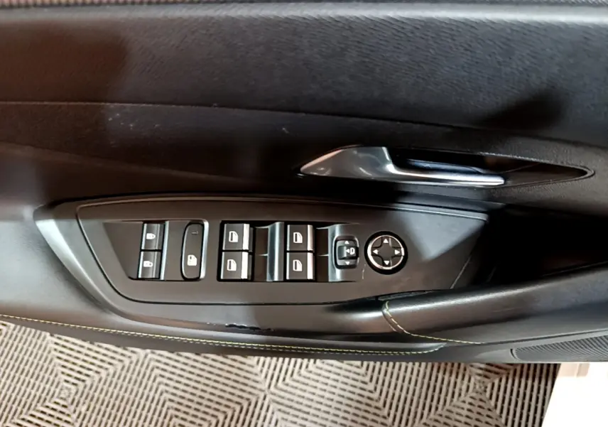 Panneau de commandes des vitres et rétroviseurs côté conducteur d'une Peugeot 308 PHEV 180 E-EAT8 GT 2022, intérieur noir.