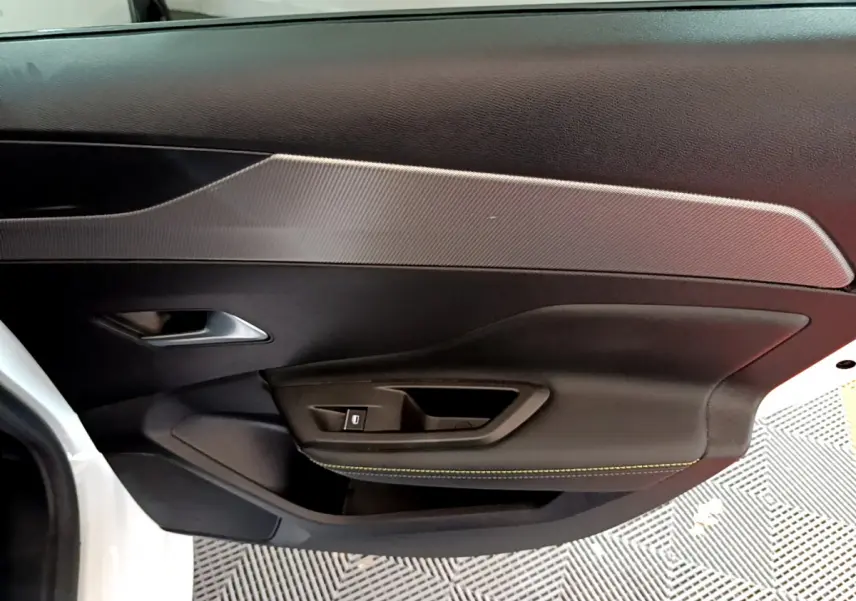 Gros plan sur la porte intérieure côté gauche de la Peugeot 308 PHEV 180 GT blanche avec surpiqûres jaunes.