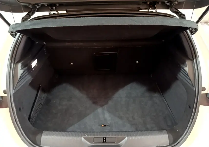 Coffre ouvert de la Peugeot 308 PHEV 180 E-EAT8 GT blanc, montrant un espace de chargement propre et spacieux.