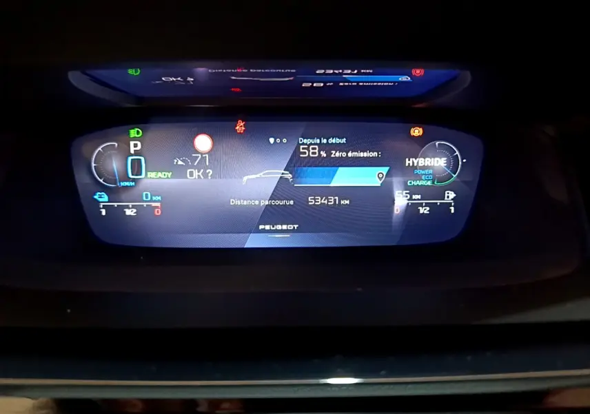 Affichage numérique du tableau de bord de la Peugeot 308 PHEV 180 E-EAT8 GT montrant l'autonomie et mode hybride.