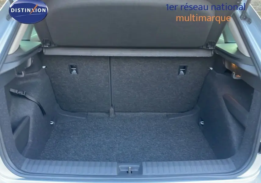 Coffre ouvert vu de l'arrière d'un Skoda Kamiq gris argent métallisé, montrant un espace de chargement propre et spacieux.