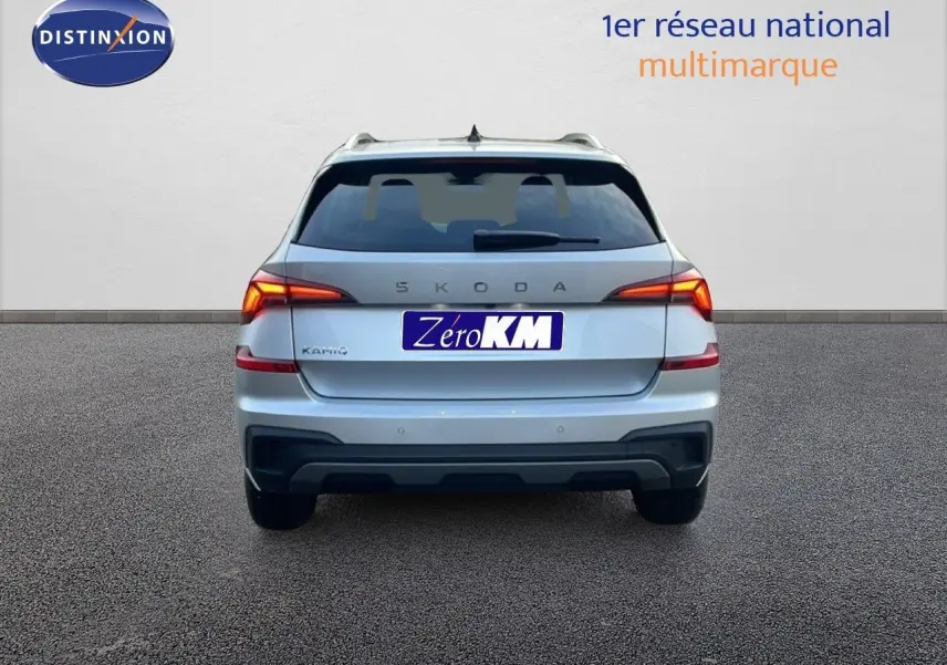 Vue arrière d'un Skoda Kamiq gris argent métal 2025 avec feux LED allumés sur fond neutre.