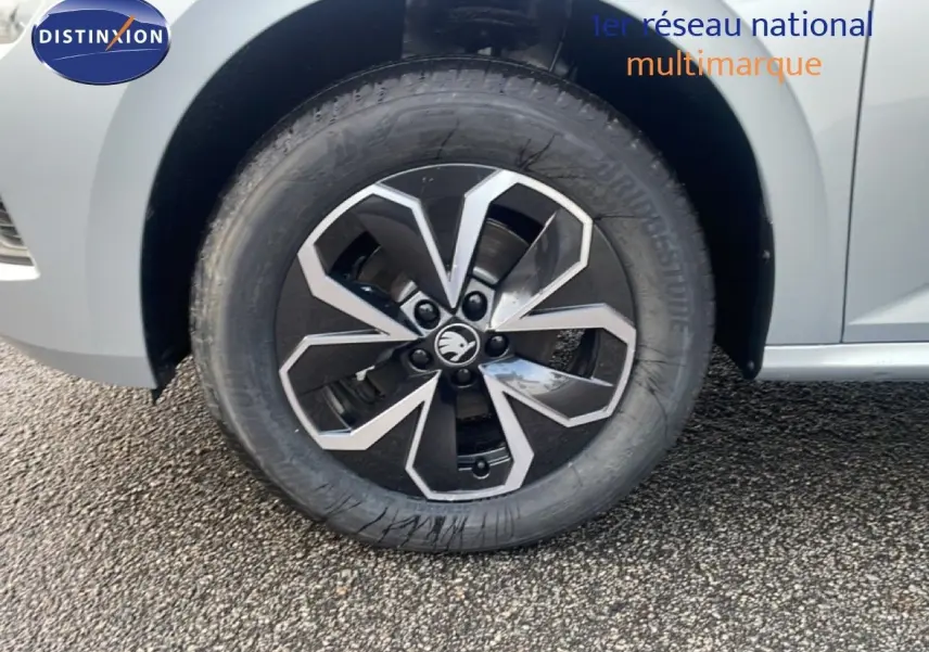 Gros plan sur la roue avant gauche d'un Skoda Kamiq gris argent métal avec jante alliage noire et argent.