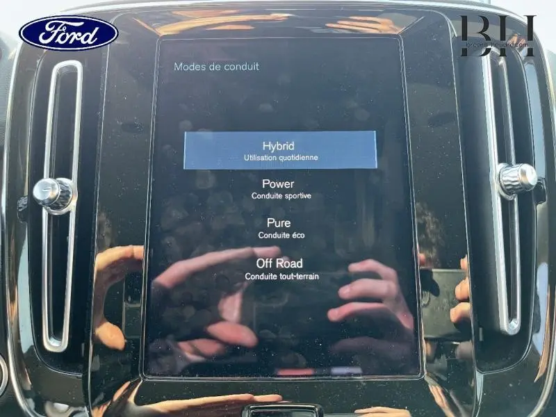 Écran tactile central affichant les modes de conduite dans un Volvo XC40 gris Glacier, vue intérieure frontale.