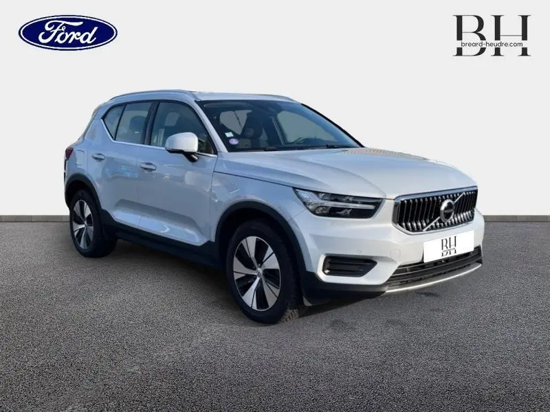 Vue 3/4 avant droite d'un Volvo XC40 T5 Recharge gris glacier avec calandre verticale chromée et jantes alu bicolores.