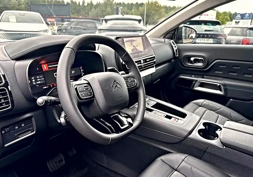 Vue intérieure côté conducteur du Citroën C5 Aircross 2025 gris platinium, avec tableau de bord digital et écran tactile central.