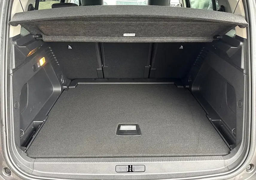 Coffre ouvert vu de l'arrière d'un Citroën C5 Aircross gris platinium, montrant le plancher de coffre plat et le cache-bagages.