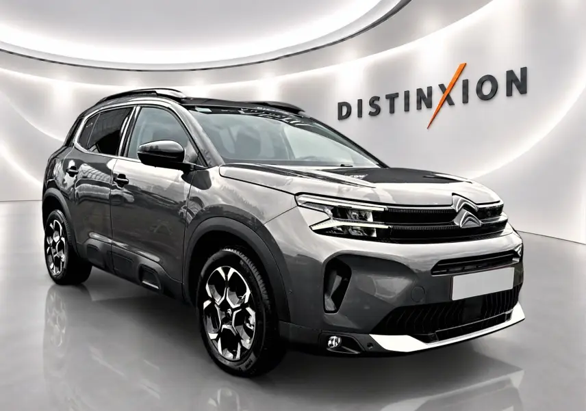 Citroën C5 Aircross gris platinium vue 3/4 avant droit en studio avec jantes alu et barres de toit.