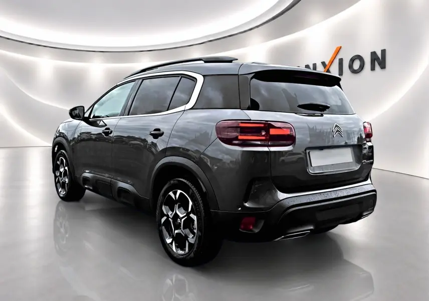 Citroën C5 Aircross gris platinium vue 3/4 arrière droit, avec jantes alu et vitres arrière teintées.