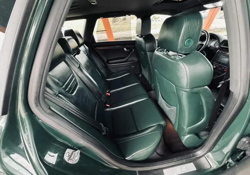 Vue intérieure arrière droite de l'Audi S4 Avant 2004 avec sièges en cuir vert foncé et détails soignés.