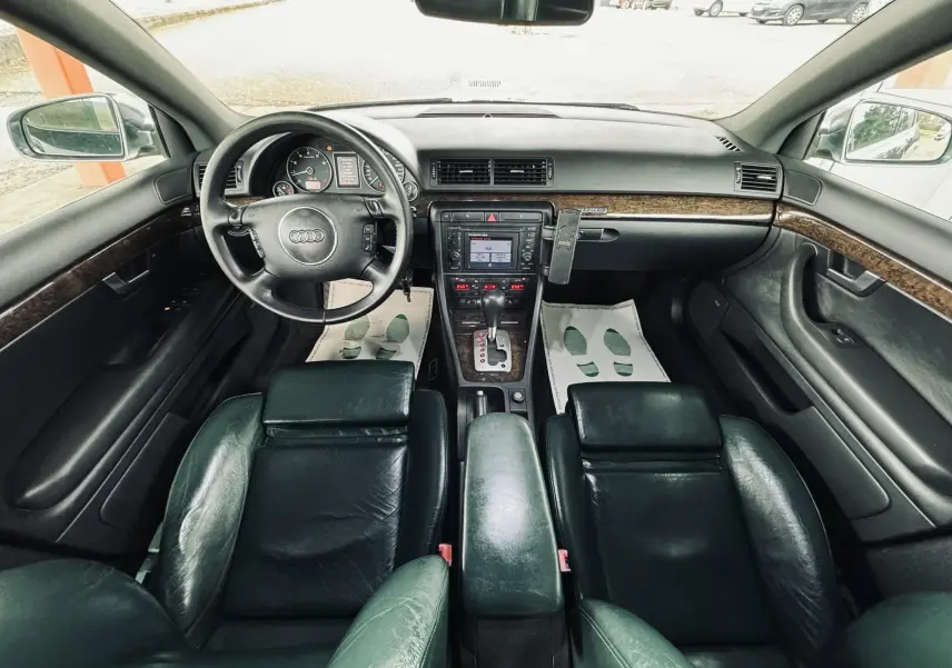 Vue intérieure de l'Audi S4 Avant 2004 montrant le tableau de bord, volant cuir et sièges noirs en cuir.