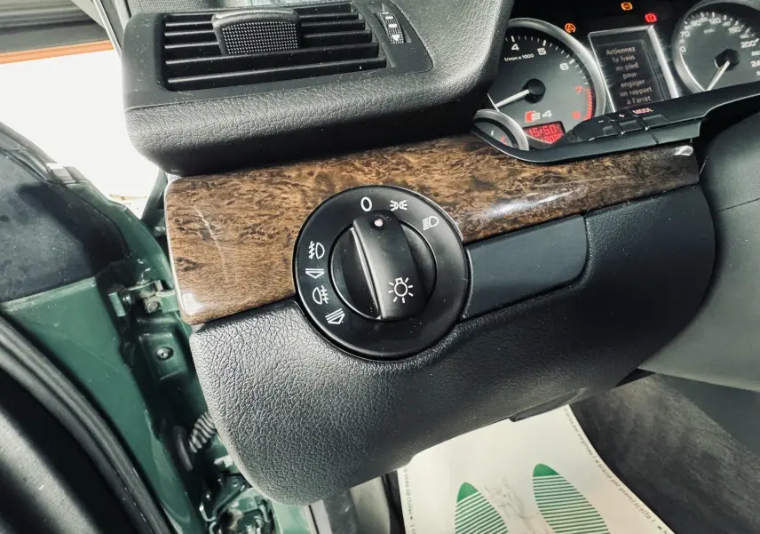 Détail du bouton d'éclairage sur tableau de bord en bois avec porte verte ouverte d'une Audi S4 Avant 2004