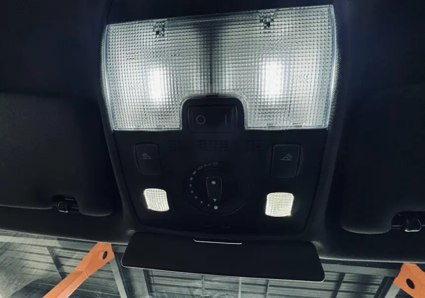 Plafonnier intérieur allumé avec commandes d’éclairage et pare-soleil noir dans l’Audi S4 Avant verte de 2004