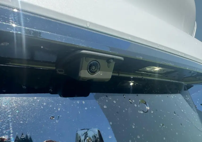 Gros plan sur la caméra de recul intégrée au pare-chocs arrière blanc Okenite de la Peugeot 308 2025.