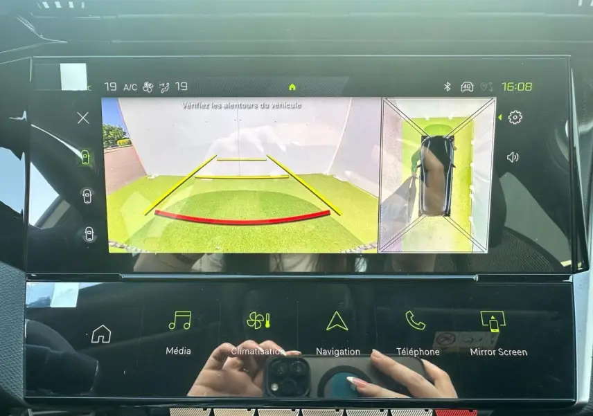 Écran tactile intérieur montrant la caméra de recul et la vue 360° d'une Peugeot 308 blanche Okenite.