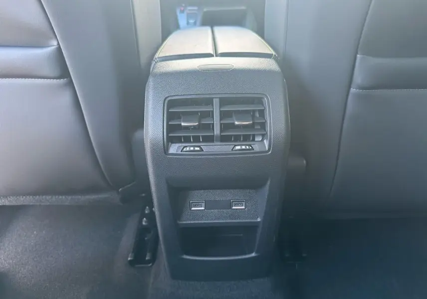 Vue rapprochée des aérateurs arrière et des deux prises USB C sur la console centrale noire du Peugeot 308 blanc Okenite.