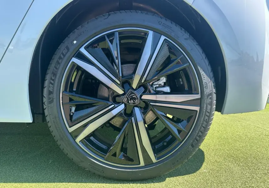 Gros plan sur la jante alliage 18'' Portland noire et argentée du côté gauche d'une Peugeot 308 blanche