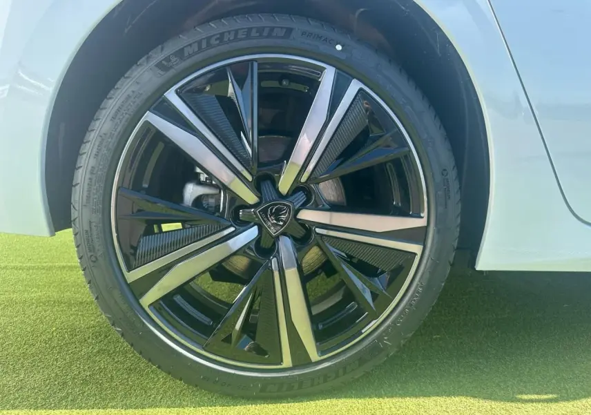 Gros plan sur la jante alliage 18'' Portland noire et diamantée du côté arrière droit d'une Peugeot 308 blanche Okenite.