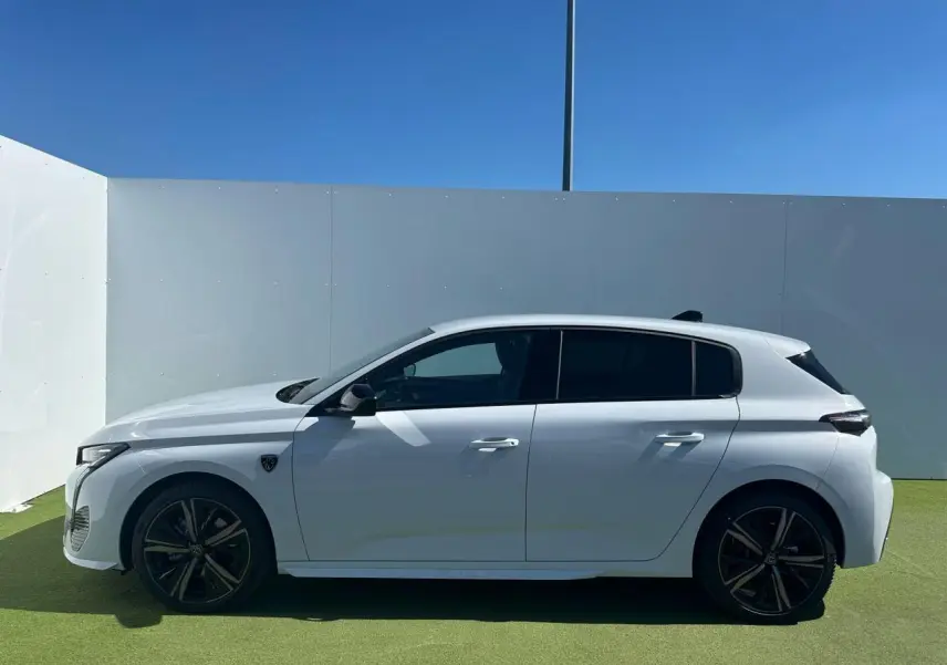 Profil côté gauche d'une Peugeot 308 blanche Okenite avec jantes alliage 18'' Portland et vitres surteintées.