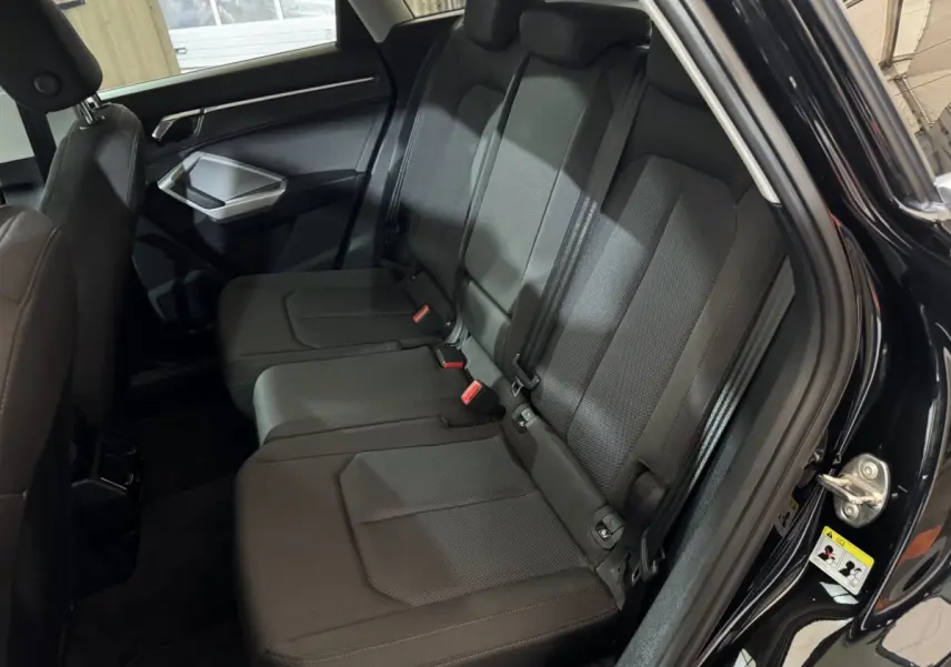 Vue intérieure côté droit des sièges arrière noirs d’un Audi Q3 35 TFSI 150 MHEV Business Line 2022.