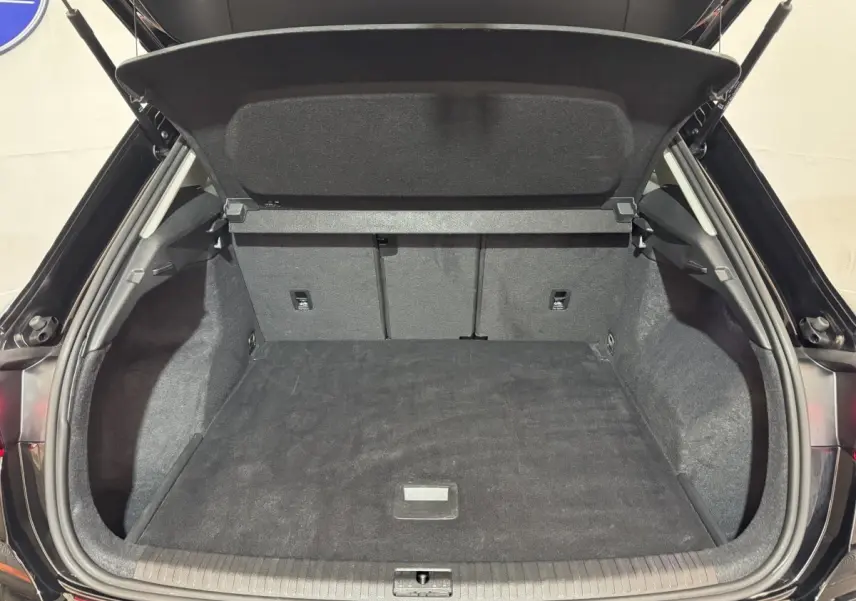 Coffre ouvert vu de l'arrière d'un Audi Q3 noir, espace de chargement propre et spacieux avec banquette rabattable.