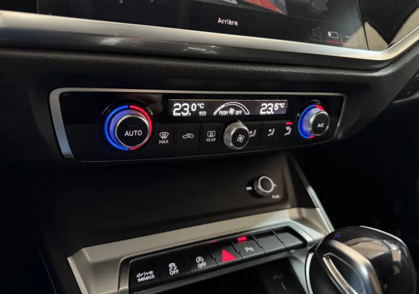 Gros plan sur la console centrale intérieure de l’Audi Q3 35 TFSI 2022, avec commandes climatisation digitale et levier de vitesse noir.