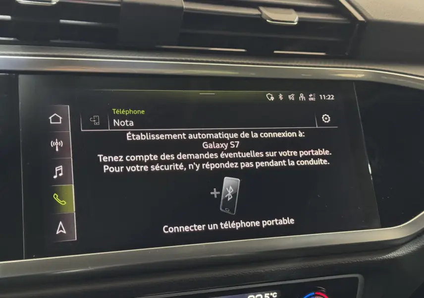 Écran tactile central de l’Audi Q3 noir 2022 affichant la connexion Bluetooth d’un téléphone portable.