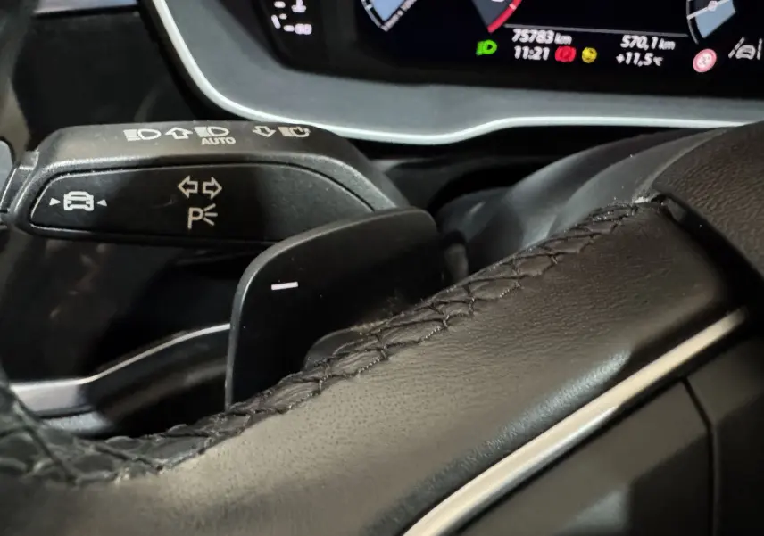 Gros plan sur le levier de clignotant et la palette de changement de vitesse du volant cuir noir d’un Audi Q3 35 TFSI 2022.