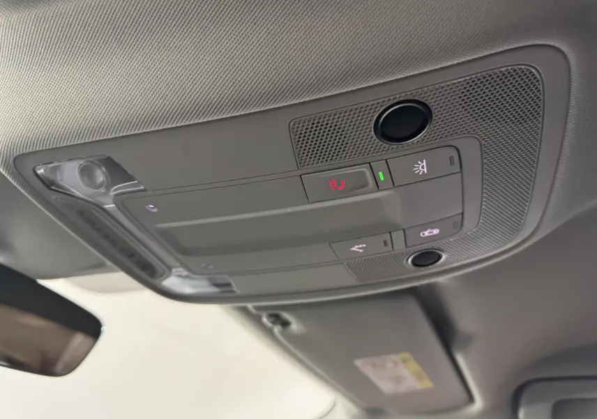 Vue intérieure en contre-plongée du plafonnier gris avec commandes d’éclairage et d’appel dans un Audi Q3 noir 2022.