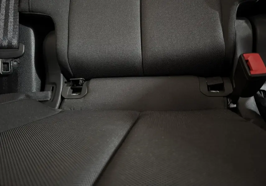Gros plan sur la banquette arrière noire de l’Audi Q3 35 TFSI 150 MHEV, avec ceinture et boucle de sécurité visibles.