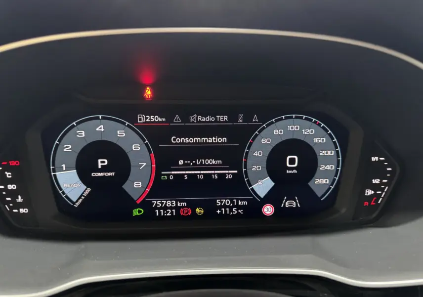 Vue rapprochée du tableau de bord numérique de l'Audi Q3 noir, affichant la consommation et les compteurs digitaux.