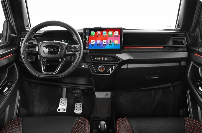 Vue frontale de l’habitacle noir et rouge du Ligier JS50 2026 avec écran tactile central et volant multifonctions.