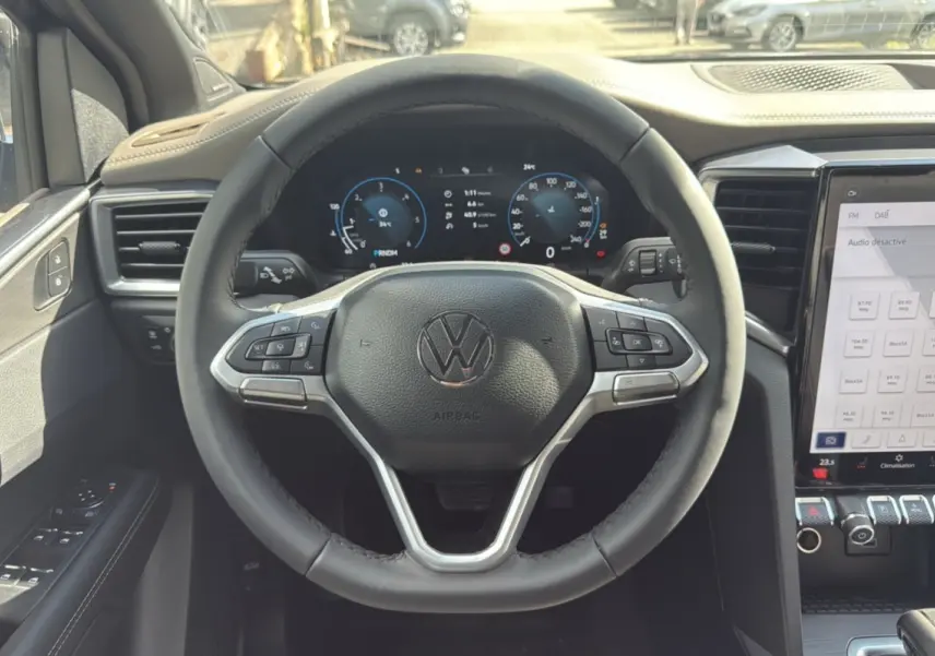 Vue intérieure centrée sur le volant Volkswagen du Amarok Simple Cabine 2025, avec tableau de bord numérique et écran tactile.