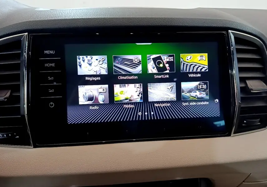 Vue rapprochée de l’écran tactile central du Skoda Karoq blanc 2023 affichant les menus multimédias et navigation.