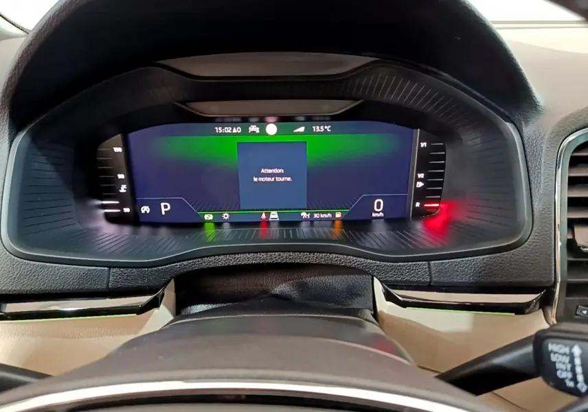 Vue rapprochée du tableau de bord numérique du Skoda Karoq 2023, affichage digital avec message moteur en marche.