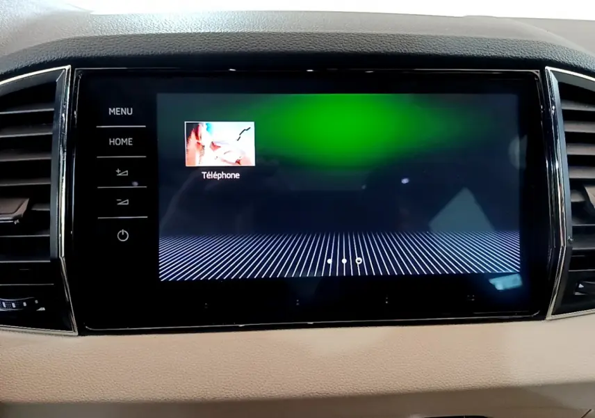 Écran tactile central allumé affichant l'option téléphone, intérieur beige du Skoda Karoq 2023.