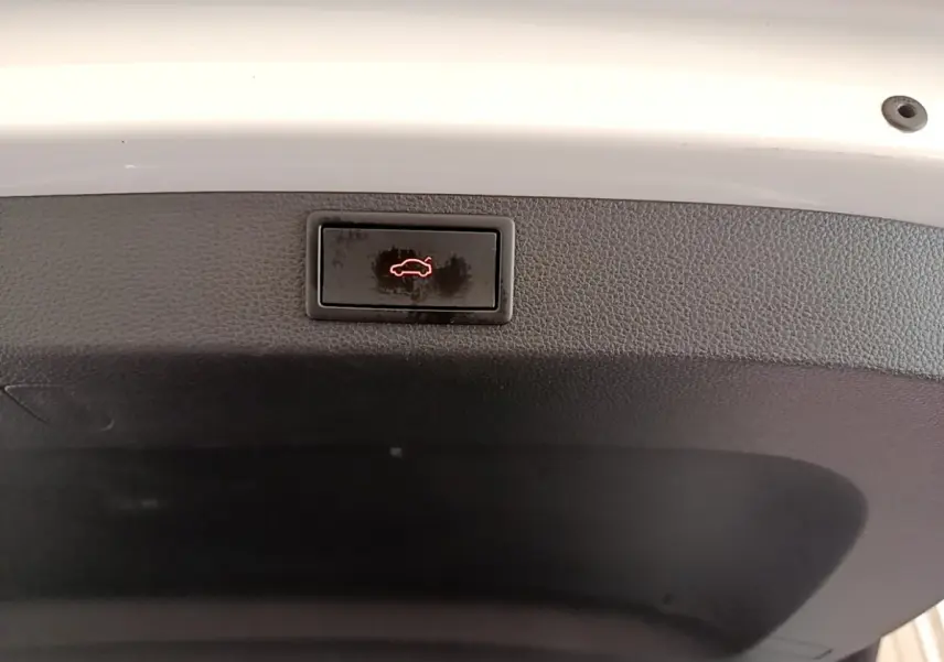 Bouton d'ouverture électrique du coffre sur la face intérieure du hayon blanc d'un Skoda Karoq 2023.