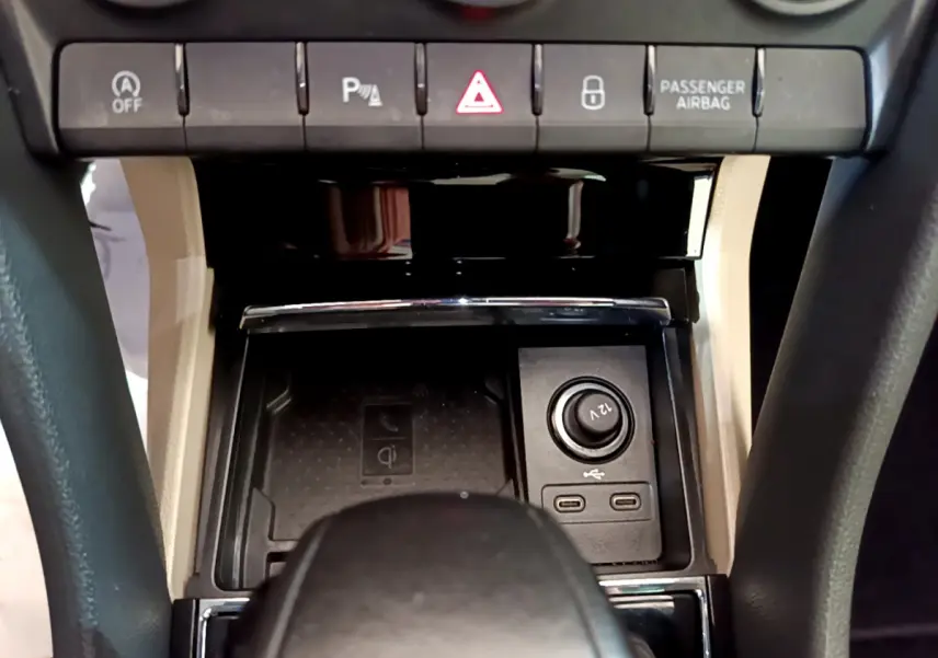 Vue rapprochée de la console centrale beige et noire du Skoda Karoq 2023, avec prises USB et bouton 12V visibles.