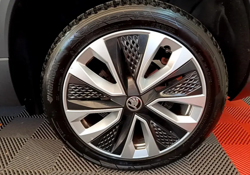 Vue rapprochée sur la roue arrière droite d’un Skoda Karoq blanc 2023 avec pneu Hankook visible.
