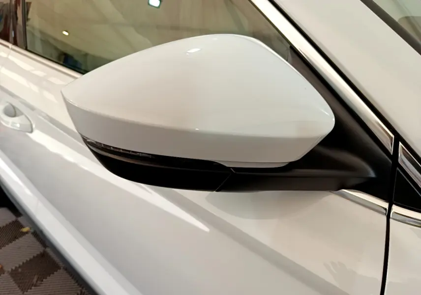 Rétroviseur côté gauche blanc du Skoda Karoq 2023, avec clignotant intégré et carrosserie blanche visible.