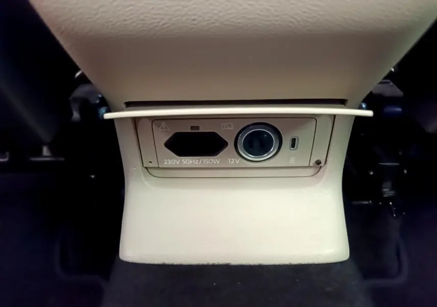 Prise 230V et 12V beige sous la console centrale arrière du Skoda Karoq blanc 2023, version Style.
