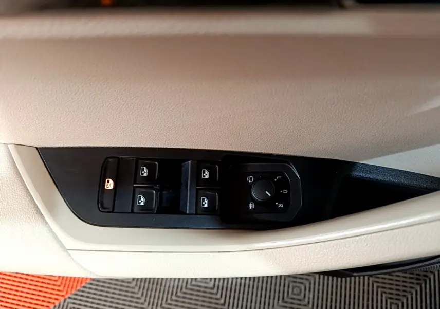 Détail des commandes des vitres et rétroviseurs sur la porte côté conducteur du Skoda Karoq blanc 2023.