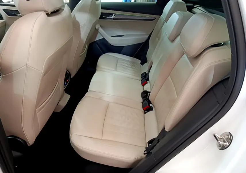 Vue intérieure côté droit des sièges arrière en cuir beige du Skoda Karoq blanc 2023, finition Style.
