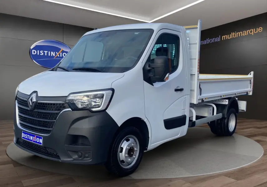 Renault Master blanc en vue 3/4 avant droit, benne arrière ouverte et pare-chocs avant noir mat.