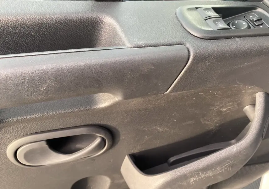 Gros plan sur la porte intérieure côté conducteur du Renault Master 2024 blanc, avec commandes de vitres et poignée noire.