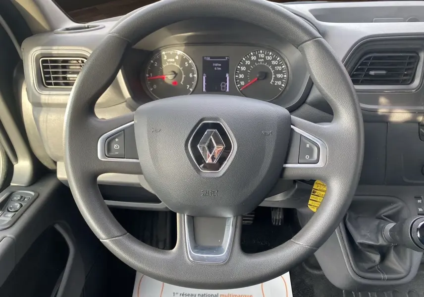 Vue intérieure centrée sur le volant noir du Renault Master 2024 avec tableau de bord et levier de vitesses manuel visible.